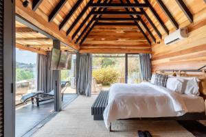 a bedroom with a bed and a large window at Ort Hotel in Campos do Jordão +87 photos