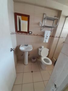 een kleine badkamer met een toilet en een wastafel bij CasaHotel Centro - Huancayo in Huancayo