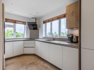 eine leere Küche mit weißen Schränken und Fenstern in der Unterkunft Avon Lock Cottage - Uk34125 in Tewkesbury