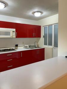 a kitchen with red cabinets and a white counter top at ACAPULCO TURQUESA DIAMANTE in Acapulco