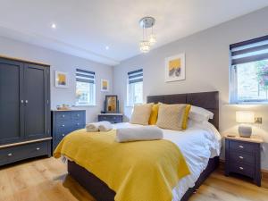 een slaapkamer met een bed met een gele deken bij Lindale Cottage in Skipton