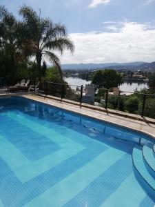 a large swimming pool with a view of a river at InterLaken Apart & Suites in Villa Carlos Paz