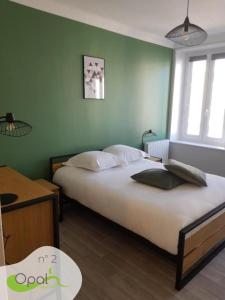 a bedroom with two beds in a room with green walls at OPAL'APPART in Boulogne-sur-Mer