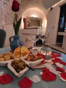 une table recouverte de assiettes de nourriture et de verres à vin dans l'établissement Piervì Suite, à Putignano