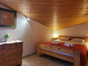 ein Schlafzimmer mit einem großen Bett und einer Holzdecke in der Unterkunft Duplex 3 pièces aux Gets, proche pistes avec parking et wifi - FR-1-598-23 in Les Gets