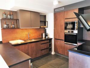 a large kitchen with wooden cabinets and a sink at Appartement cosy en duplex, 8 pers, parking, Les Gets - FR-1-598-59 in Les Gets