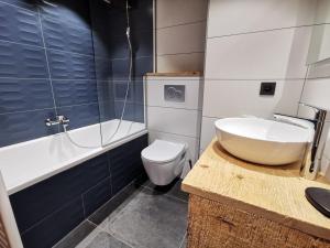 a bathroom with a sink and a toilet and a tub at Appartement de Charme 4* au Centre des Gets - Accès Direct aux Pistes de Ski - FR-1-598-28 in Les Gets +7 photos