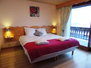 a bedroom with a bed with a red blanket at Les Gets : Appt 10 pers skis aux pieds, balcon, parking, wifi - FR-1-598-72 in Les Gets