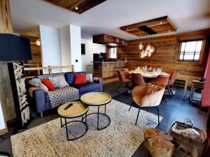 a living room with a blue couch and a table at Exceptionnel duplex avec vue panoramique, terrasse et garage aux Gets - FR-1-598-36 in Les Gets