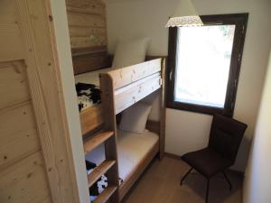 a bunk bed in a tiny house with a chair at Appartement Les Gets, 2 pièces, 6 personnes - FR-1-598-5 in Les Gets