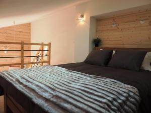 a bedroom with a bed with a wooden wall at Appartement Les Gets, 2 pièces, 6 personnes - FR-1-598-5 in Les Gets