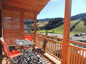 a wooden deck with a table and chairs on it at T3 aux Gets, vue sur pistes - FR-1-598-5 in Les Gets +8 photos