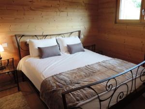 a bed in a log cabin with two pillows at Chalet Les Gets, 4 pièces, 6 personnes - FR-1-598-10 in Les Gets
