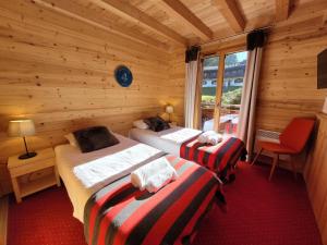 a bedroom with two beds in a log cabin at Appartement Les Gets, 3 pièces, 6 personnes - FR-1-598-71 in Les Gets