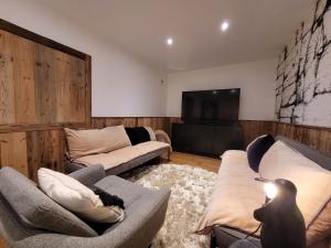 een woonkamer met 2 banken en een flatscreen-tv bij Chalet Les Gets, 5 pièces, 14 personnes - FR-1-598-19 in Les Gets