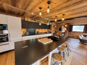 a kitchen with a black counter top and wooden ceilings at Chalet Les Gets, 5 pièces, 14 personnes - FR-1-598-19 in Les Gets