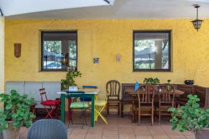 un patio con sillas, una mesa y una pared amarilla en Hotel Rural Xerete, en Navaconcejo