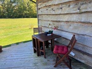 - une table en bois et 2 chaises sur la terrasse dans l'établissement Smiths mother-in-law suite! Pet friendly!, à Valley Head