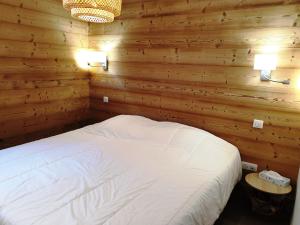 a bedroom with a bed in a wooden wall at Appartement Cosy 3 pièces avec Balcon, Garage et Wi-Fi - FR-1-598-40 in Les Gets