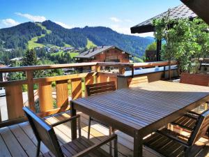 a wooden table and chairs on a deck with a view at Appartement Les Gets, 3 pièces, 5 personnes - FR-1-598-48 in Les Gets