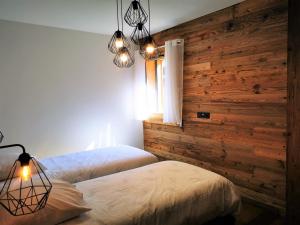 a bedroom with two beds and a wooden wall at Appartement Les Gets, 3 pièces, 5 personnes - FR-1-598-48 in Les Gets