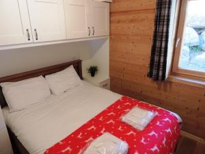 a bedroom with a bed with a red blanket on it at Grand appartement familial avec garage et WiFi, 3 chambres pour 8 personnes - FR-1-598-55 in Les Gets