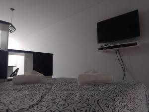 a bedroom with a bed with a flat screen tv on the wall at Alquiler Temporario Rosario 4 in Rosario