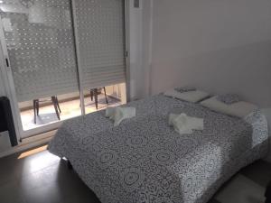 1 dormitorio con cama con almohadas y ventana en Alquiler Temporario Rosario 4 en Rosario
