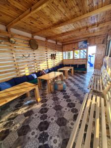 una habitación con bancos y mesas en una cabaña en LAFAMILIA SURF imsouane, en Imsouane