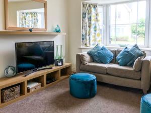 a living room with a couch and a tv at Arthurs Place in Reighton