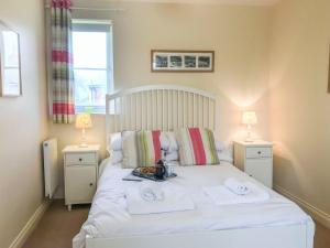 a bedroom with a white bed with towels on it at Arthurs Place in Reighton