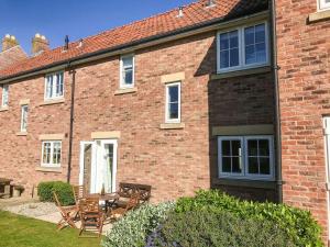 a brick house with a table and chairs in the yard at Arthurs Place in Reighton