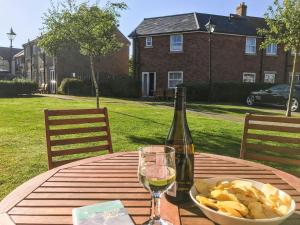 a table with a bottle of wine and a bowl of chips at Arthurs Place in Reighton