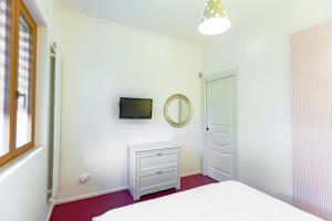Schlafzimmer mit einem weißen Bett und einem Spiegel in der Unterkunft Casa Morgana in Giovinazzo