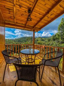 a patio with chairs and a table on a deck at Altares de Oxapampa in Oxapampa