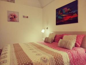 a bedroom with a large bed with pink and white sheets at La Maison apartment Puglia in Molfetta