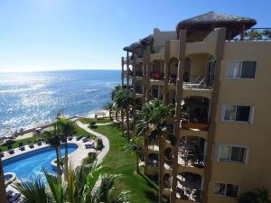 a building with a swimming pool next to the ocean at Sub- Penthouse Las Olas Surfers Paradise in San José del Cabo