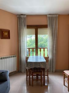 a dining room with a table and chairs and a window at Casa Miranda in Campo