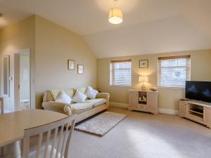 a living room with a couch and a television at The Parlour - Uk36122 in Horsington