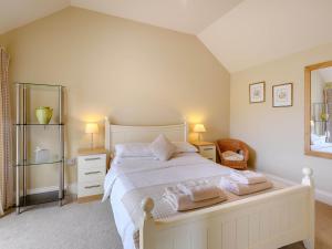 um quarto com uma cama branca com duas toalhas em The Parlour - Uk36122 em Horsington
