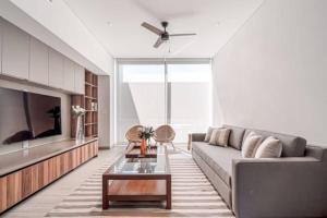 a living room with a couch and a tv at Amazing Cabo Marina condo with private jacuzzi in Cabo San Lucas