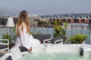 a woman standing in a bath tub on a roof at Sky Roof Apartments in Bielsko-Biała
