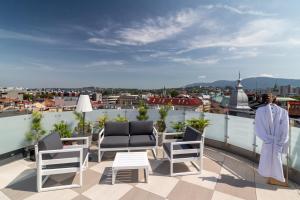 a patio with chairs and a table on a roof at Sky Roof Apartments in Bielsko-Biała