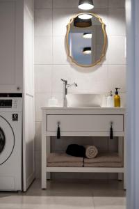 a bathroom with a sink and a washing machine at Cesar Apartman in Sopron