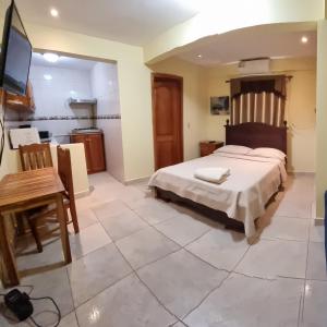 a bedroom with a large bed and a kitchen at Hostal Bocas Tropical Paradise in Bocas Town