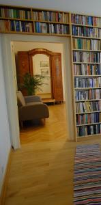 een woonkamer met een bibliotheek met boeken bij Meta Biblioteka in Puławy