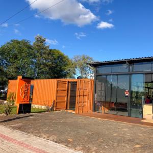 Pousada Container e Spa Mina Beer في Ametista do Sul: مبنى برتقالي بجانب مبنى