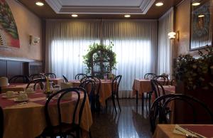 a room with tables and chairs in a restaurant at Hotel Roma in Marghera