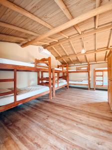 a group of bunk beds in a room with wooden ceilings at Caramuru Hostel Caraíva in Caraíva