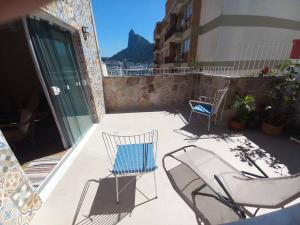 a patio with two chairs and a table and chairs at Espaço, Conforto e vista para o Cristo no Rio. in Rio de Janeiro +20 photos
